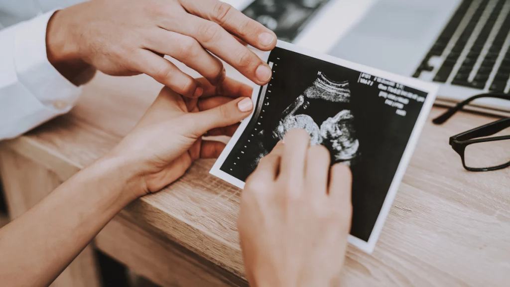 dr.consulta-imagem mostra uma mulher segurando uma imagem de um feto em um consultório médico; exames do pré-natal