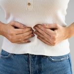 drconsulta - diverticulite, mulher com as mãos no estômago, com dor, inflamação no intestino