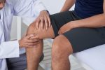 Exame clínico de dor no joelho realizado por médico ortopedista