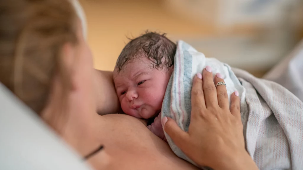 dr.consulta - quando procurar um obstetra, mulher com bebê recém-nascido no colo, pós-parto, acompanhamento após o nascimento