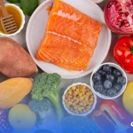 Imagem de diversos alimentos ricos em vitamina b12 sob uma mesa, incluindo peixe, romã e etc.