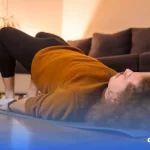 Imagem de um homem deitado no chão de uma sala fazendo exercícios de contração pélvica.