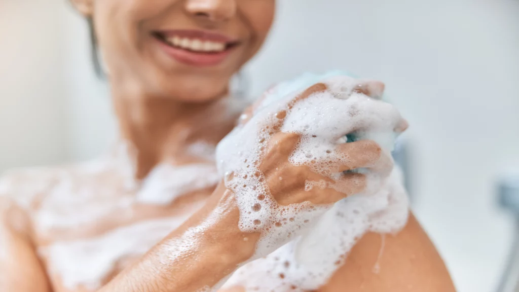 Imagem de uma mulher sorrindo ao tomar banho.