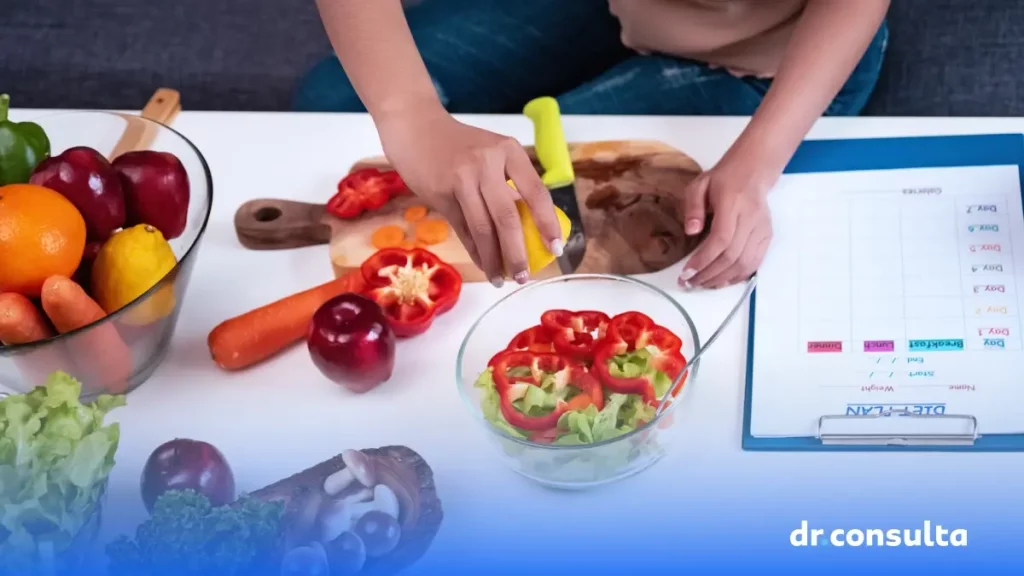 Imagem de uma pessoa espremendo um limão em uma salada. Também é possível perceber outros alimentos em cima de uma mesa, além de uma prancheta organizadora.