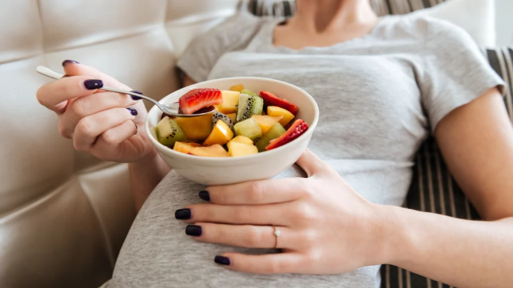 dr.consulta - imagem mostra uma gestante, sem exibir seu rosto, com um pratinho de salada de frutas apoiado em sua barriga; cuidados na gravidez