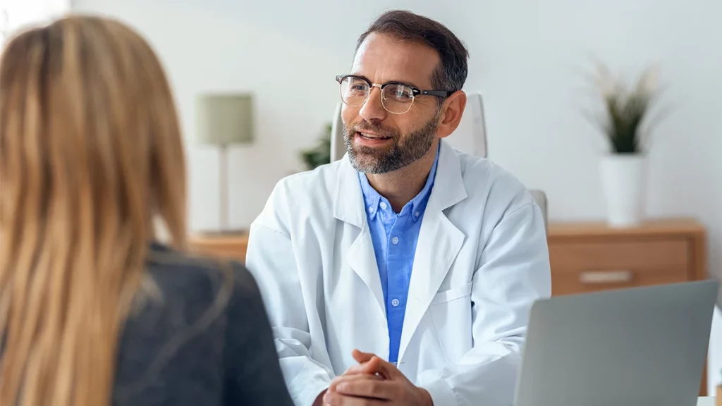dr.consulta-médico, usando jaleco e óculos, aconselha paciente sobre quando procurar um homeopata