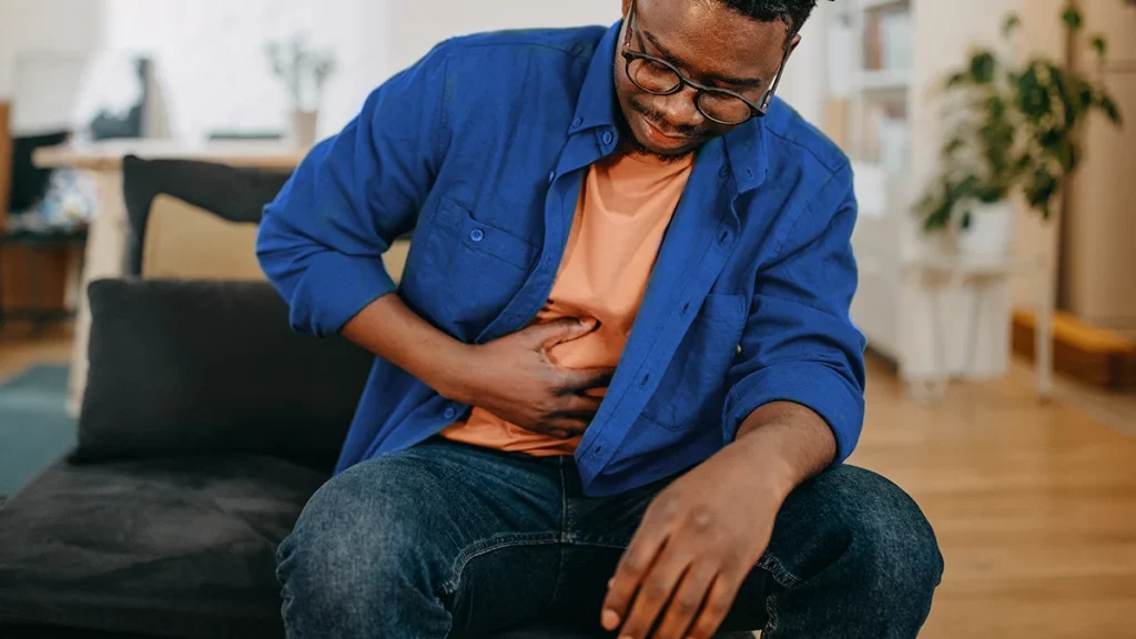 dr.consulta - homem com as mãos na barriga com sintomas de gases, gases em excesso, causas dos gases excessivo