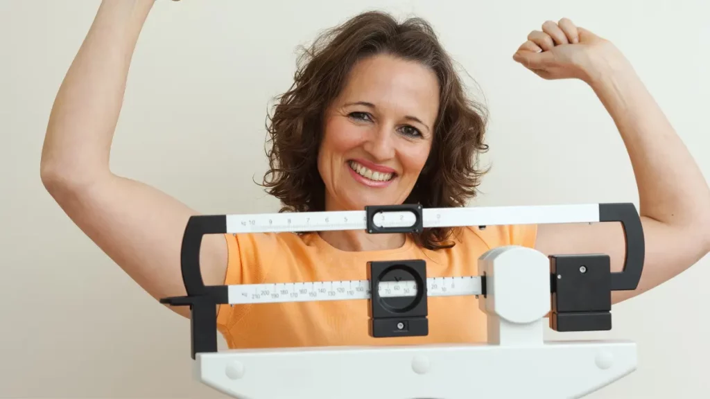 dr.consulta - mulher feliz com o peso ideal medido em uma balança de consultório, perda e ganho de peso, efeito sanfona