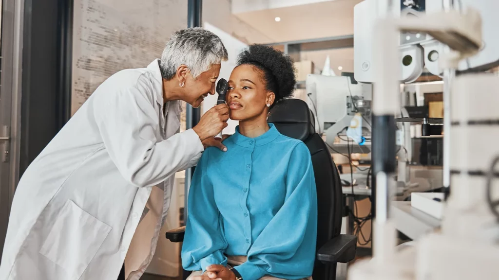 dr.consulta - oftalmologista mulher fazendo exame de rotina em uma paciente negra que está sentada na cadeira de um consultório, estrabismo, causas do estrabismo, tratamentos