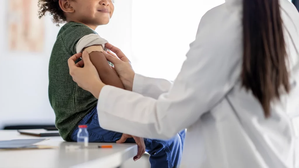 dr.consulta - menino valente sorri para a enfermeira após receber a dose da vacina contra coqueluche