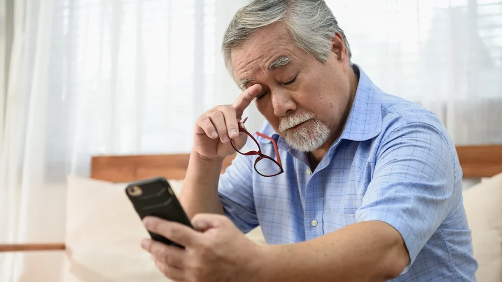 dr.consulta - homem com óculos forçando a visão para enxergar o que está no computador, vista cansada, exame preventivo de visão