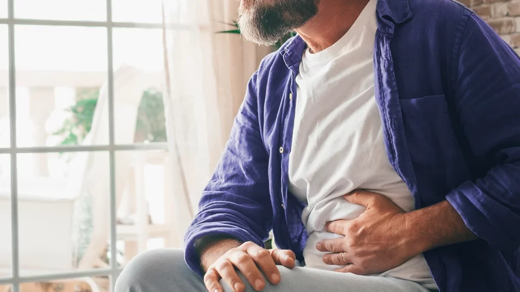 dr.consulta - homem com as mãos na barriga, com dor abdominal, sintomas da colite