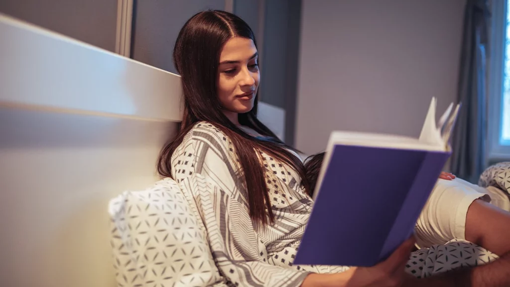 dr.consulta - mulher jovem lendo um livro para relaxar antes de dormir, dormir melhor, melatonina, hormônio do sono