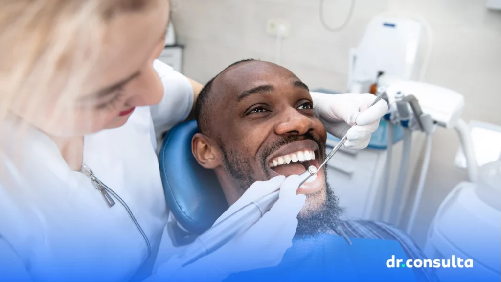 dr.consulta - homem negro sentado em um consultório odontológico, acompanhamento com dentista, cuidados com os dentes, lente de contato dental