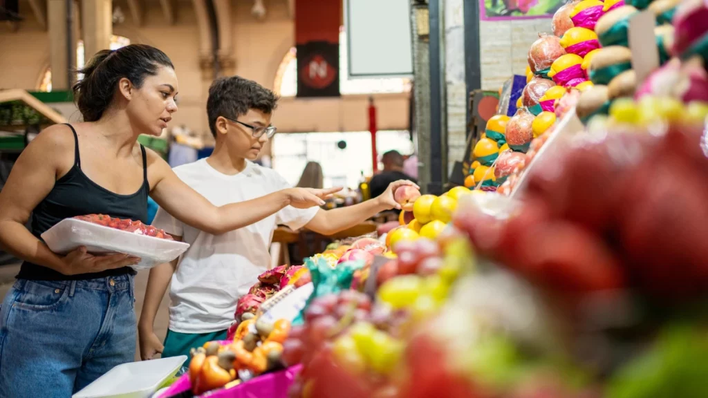 dr.consulta - mulher e menino escolhendo frutas em banca de frutas do mercadão, frutas para diabéticos, cardápio com frutas