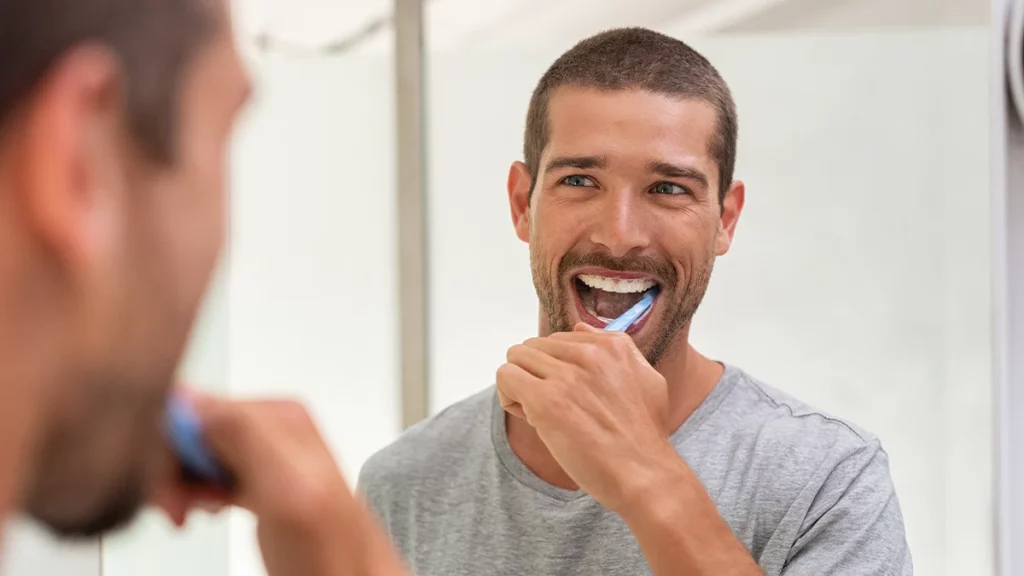 dr.consulta - homem escovando os dentes e a língua para evitar a língua branca e outras doenças bucais