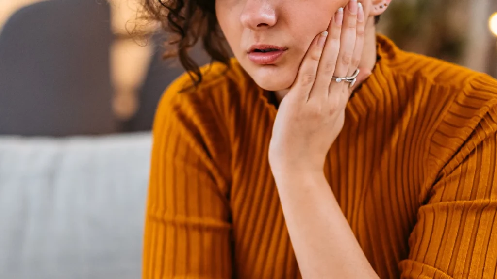 dr.consulta - abcesso dentário, mulher com as mãos na bochecha, dor de dente, tratamento dentário