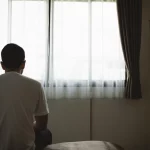 dr.consulta - homem sentado no quarto, apático olhando para o nada com sintomas da depressão