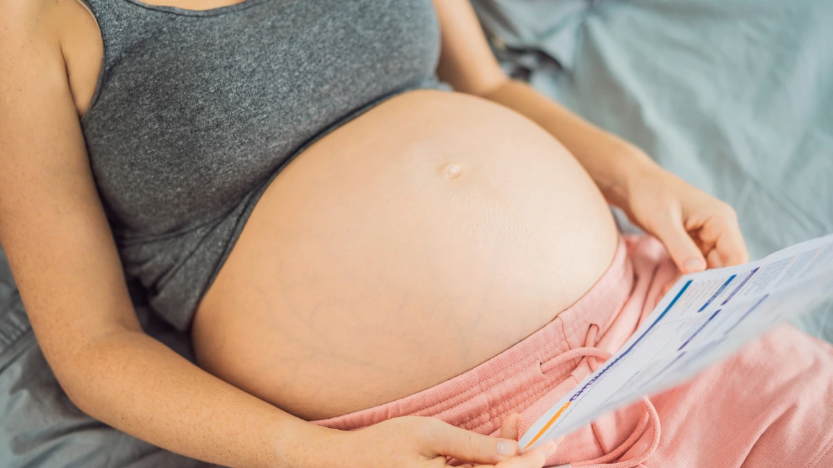 dr.consulta - Barriga de grávida com resultados de exame de glicose na gravidez apoiados nela.