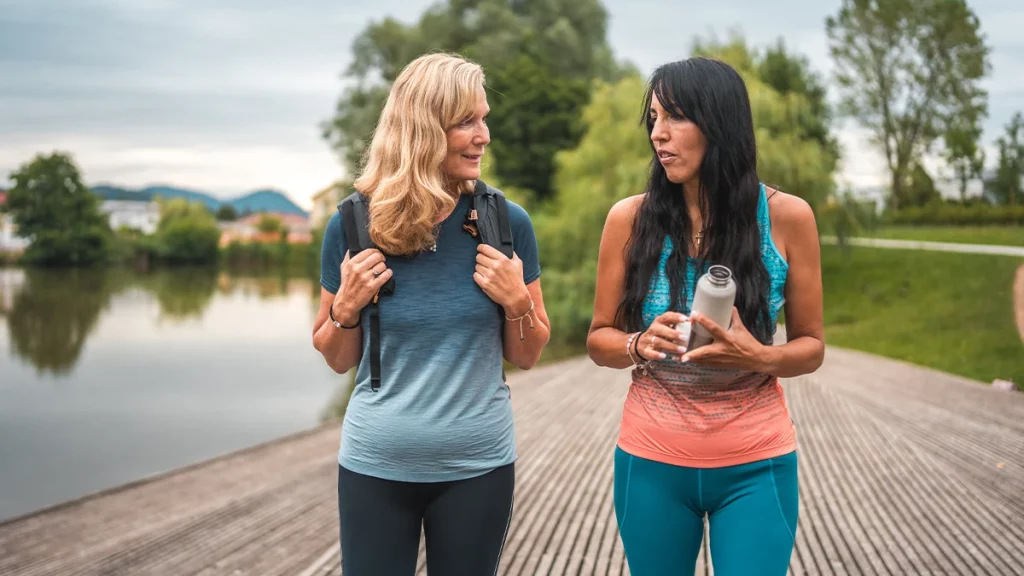 dr.consulta - Duas mulheres adultas caminhando e conversando ao ar livre, possivelmente na pós-menopausa