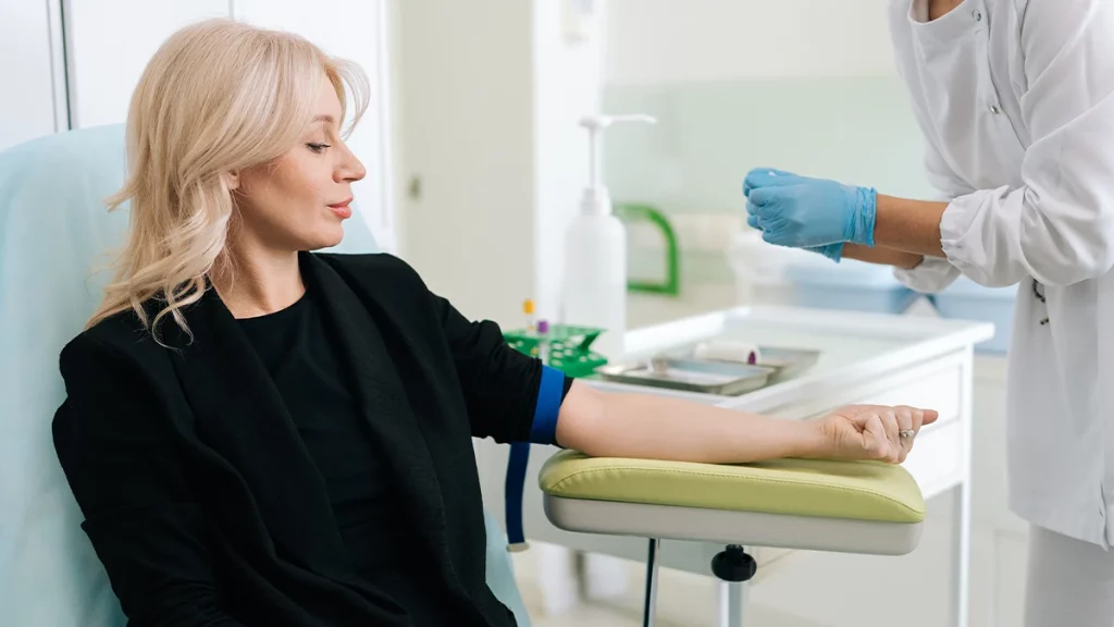 dr.consulta - Na imagem, mulher com o braço estendido e apoiado para coletar sangue, ilustrando o que é o perfil lipídico.