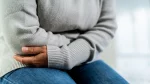 dr.consulta - Na imagem, mulher apertando a barriga em sinal de dor por cólica abdominal.