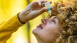 dr.consulta - Na imagem, mulher de cabelos cacheados aplica medicamento nos olhos, simbolizando a importância de se atentar ao uso incorreto do colírio.