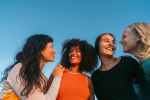 grupo de mulheres sorrindo juntas ao ar livre representando bem-estar, autocuidado e saúde da mulher
